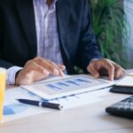 man in a suit looking at a chart on an ipad